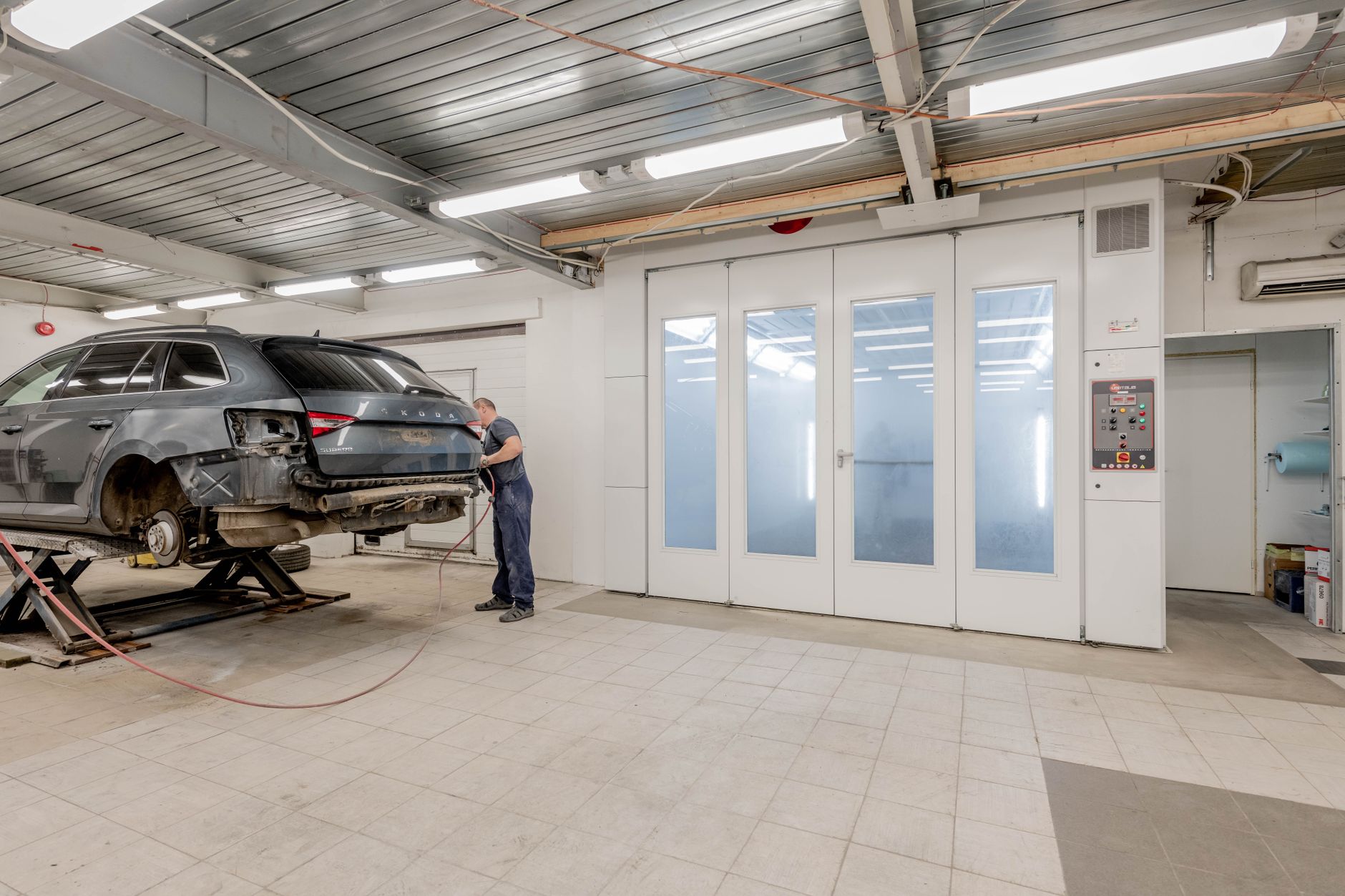 Mechanic repairing a car indoors at an auto body shop