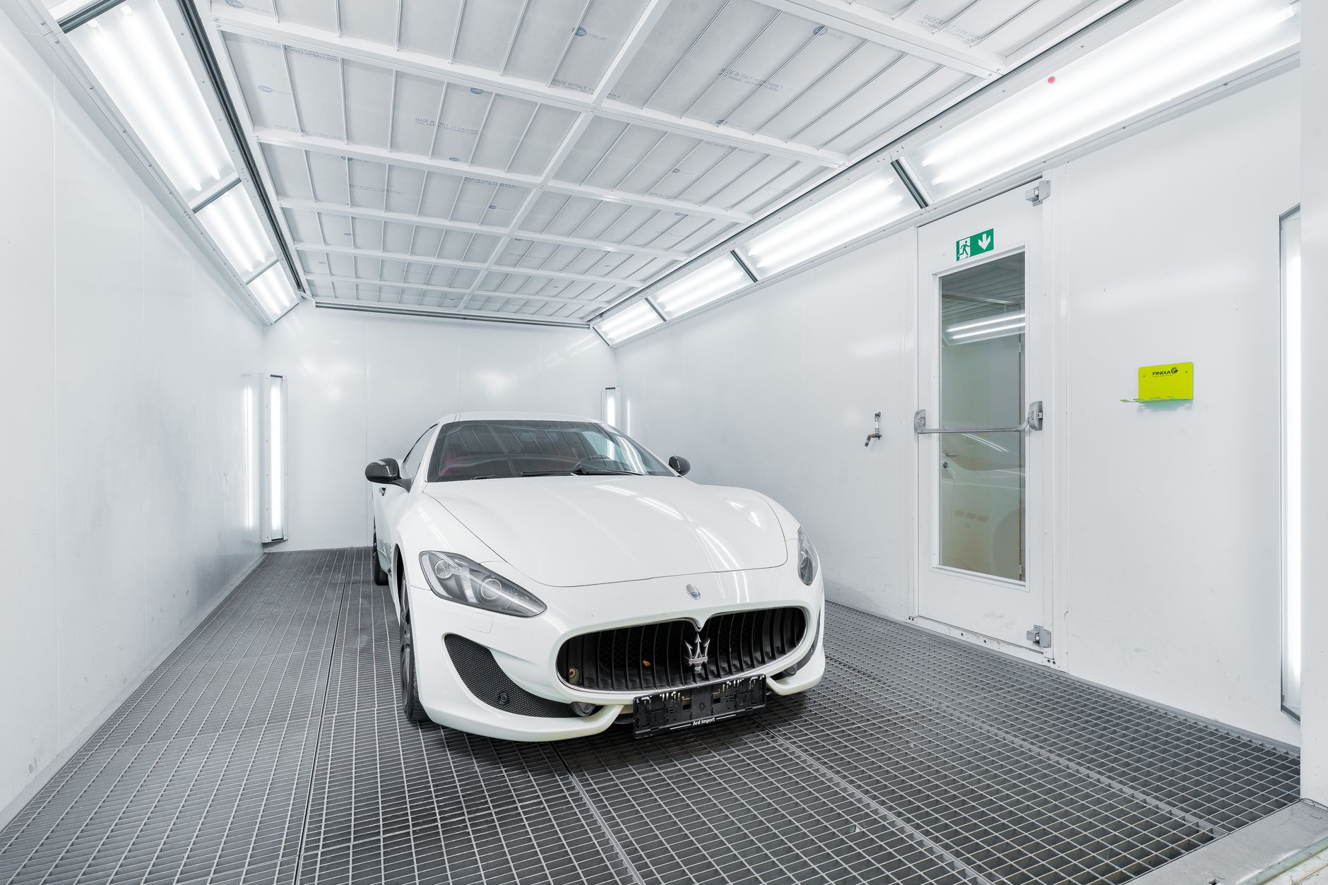 Car inside a paint booth at an auto body shop