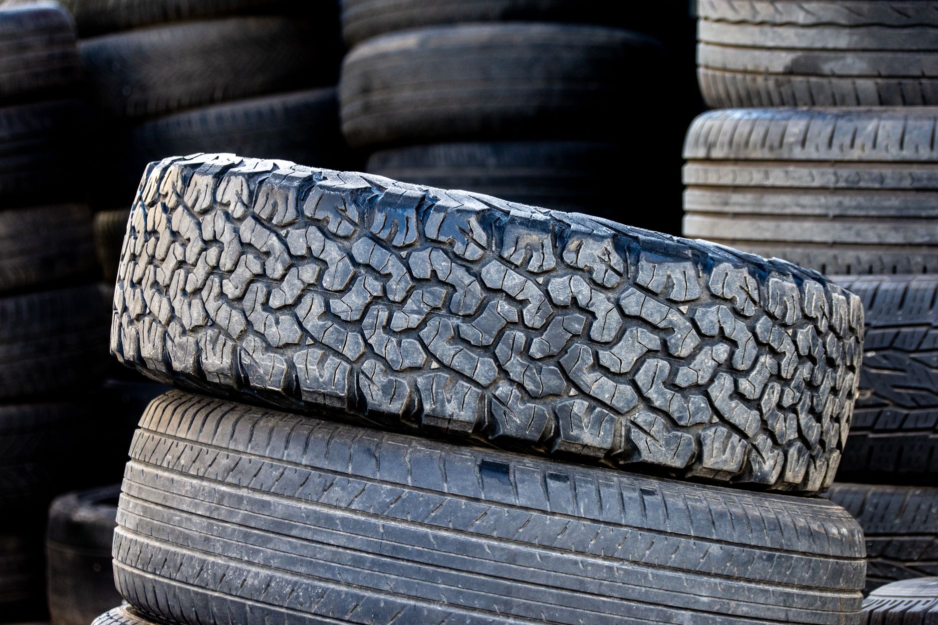 Stack of automotive tires with tread patterns visible