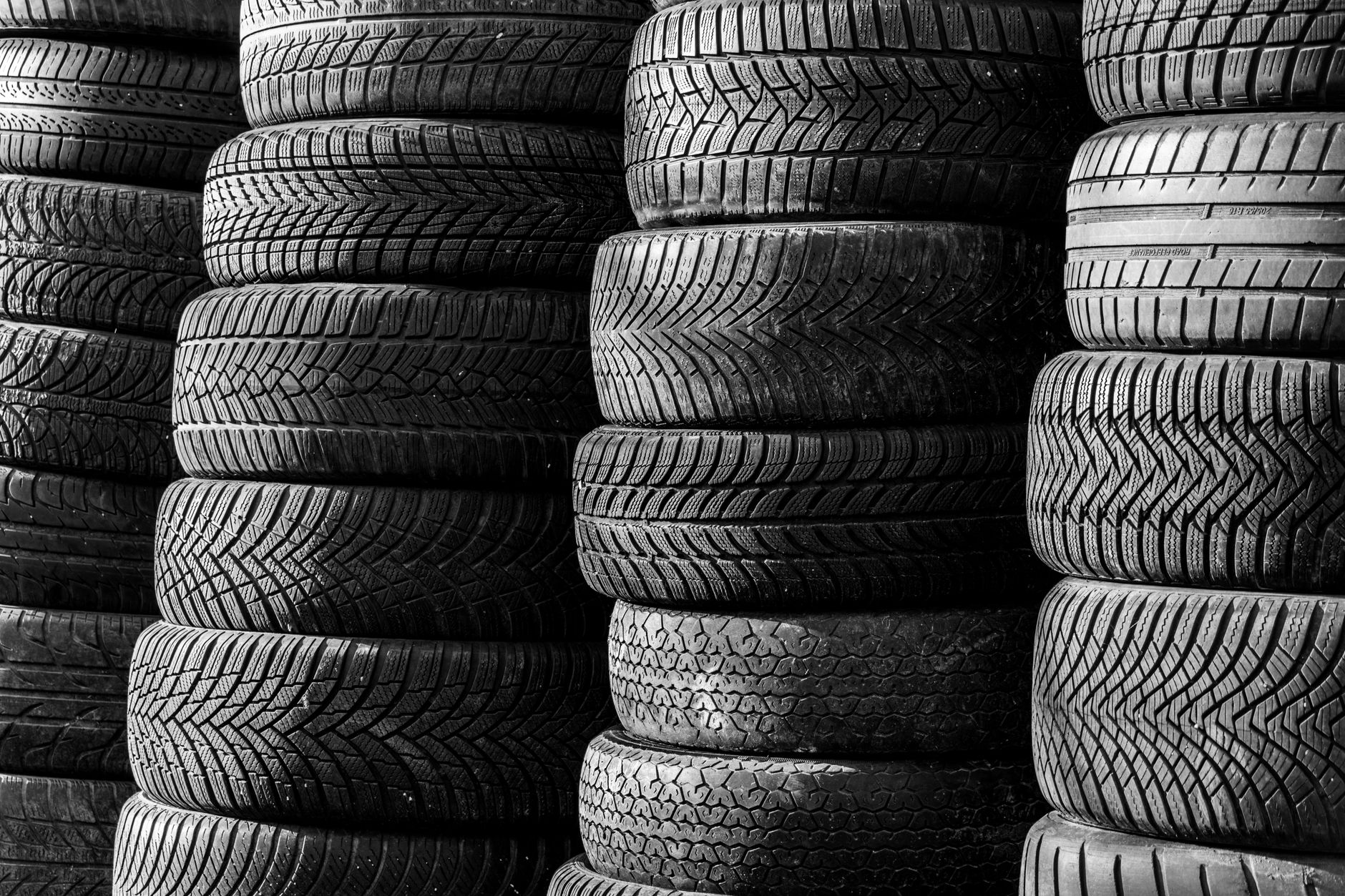 Stacked vehicle tires showing various tread patterns