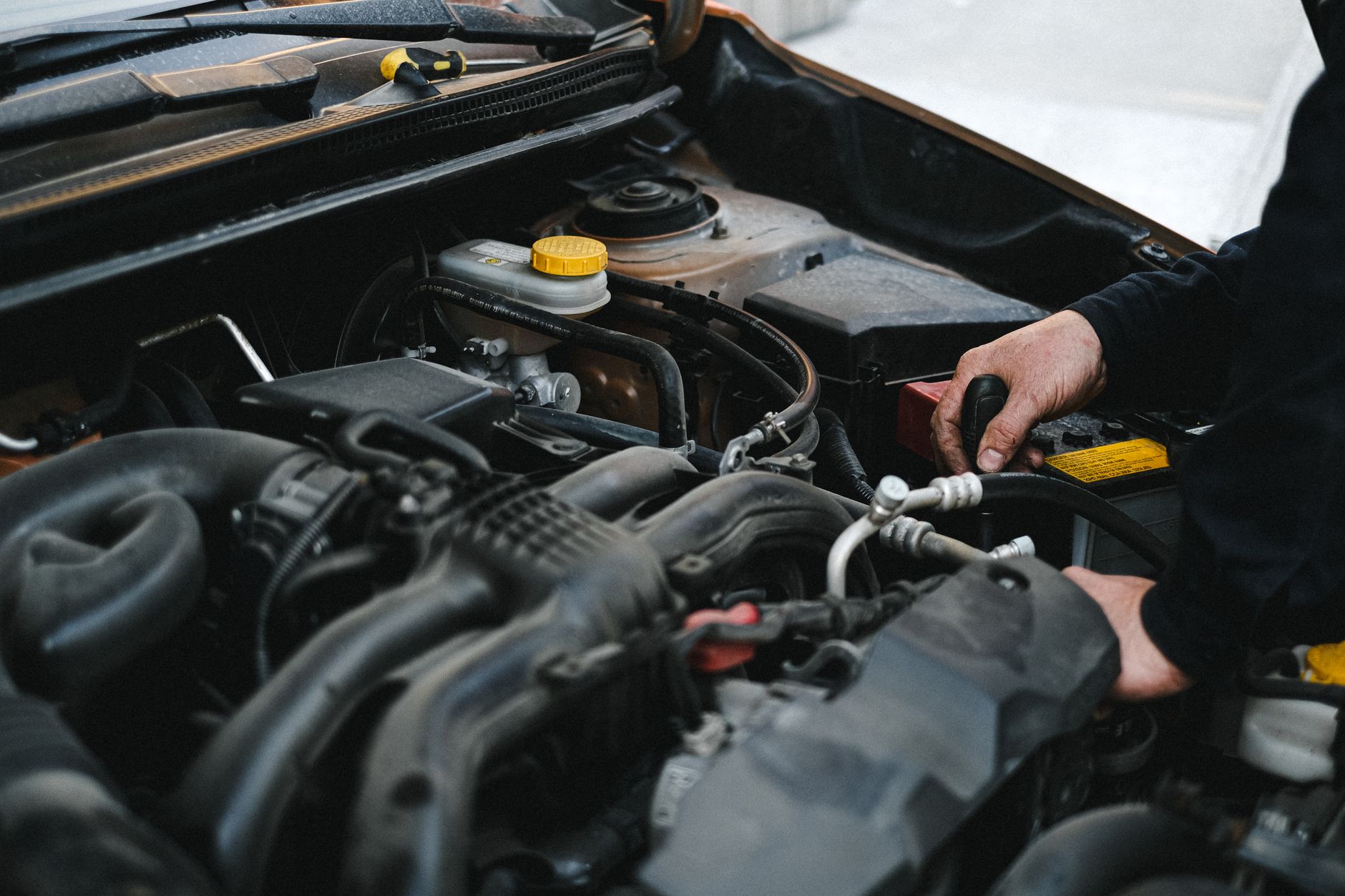Close-up of a mechanic's hands working on a car engine