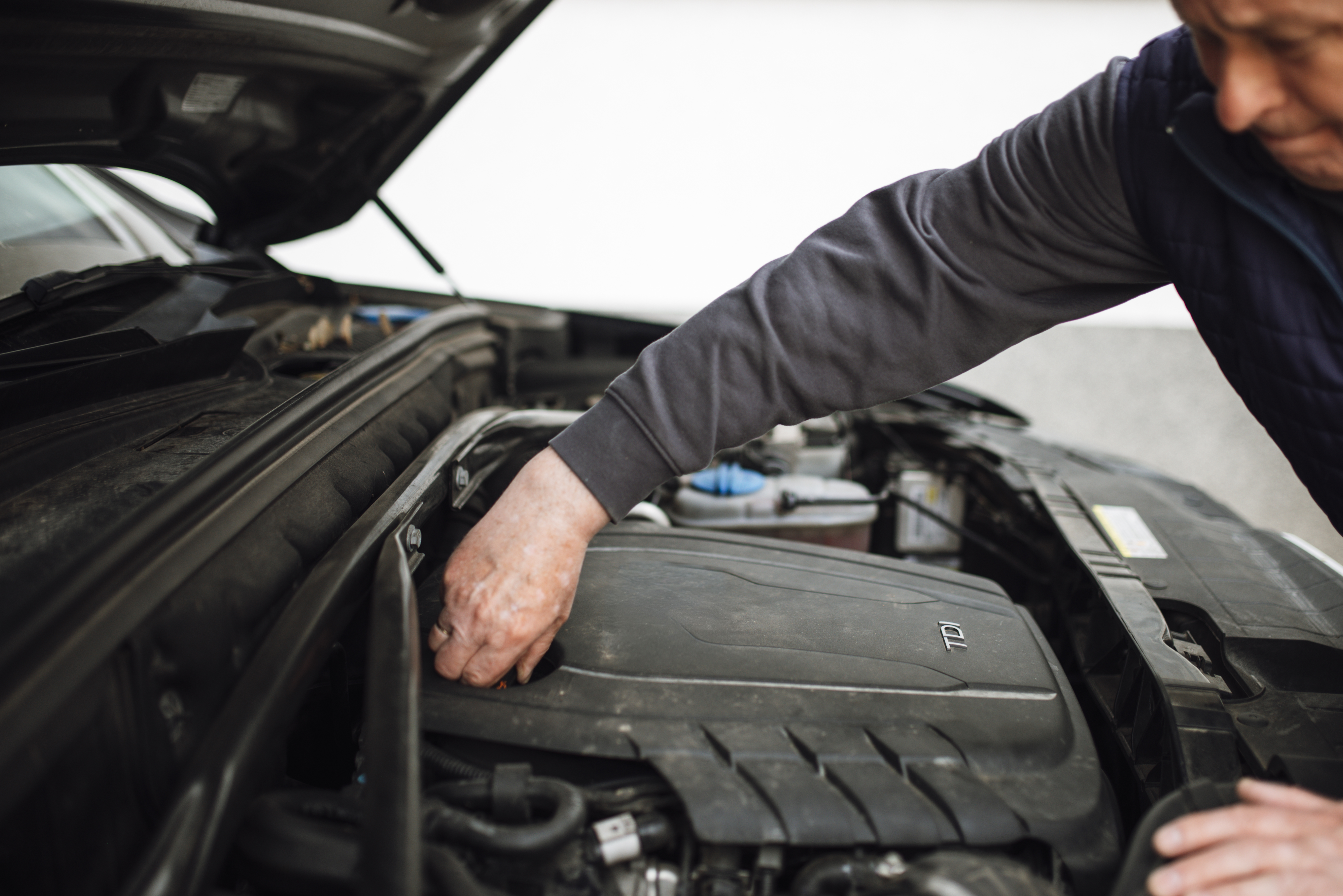 Mechanic inspecting a car engine during routine maintenance