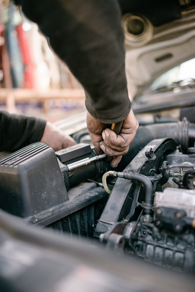 Mechanic working on a car engine under the hood